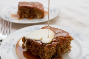 pouring double cream over sticky toffee and date pudding