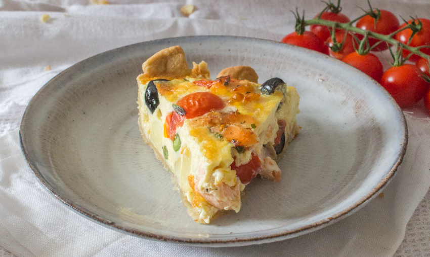 Slice of quiche showing all the ingredients inside